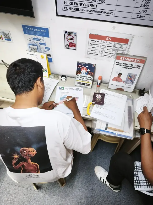 Applicant filling out forms at a Japan visa application desk