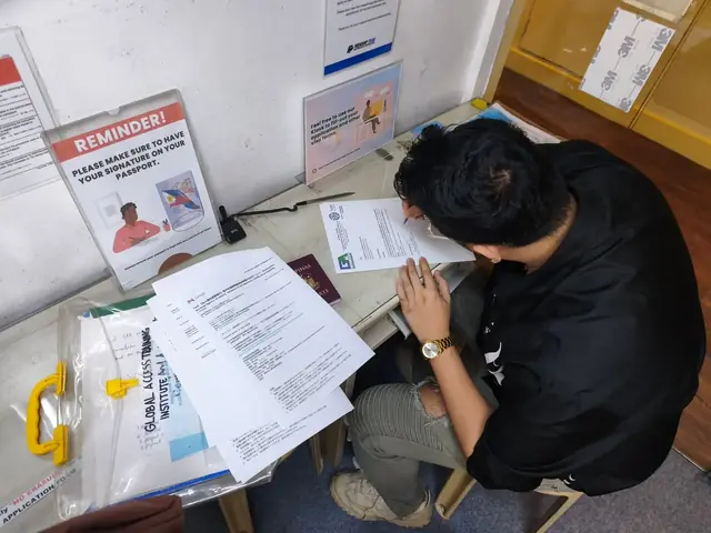 Applicant filling out visa application forms at a desk