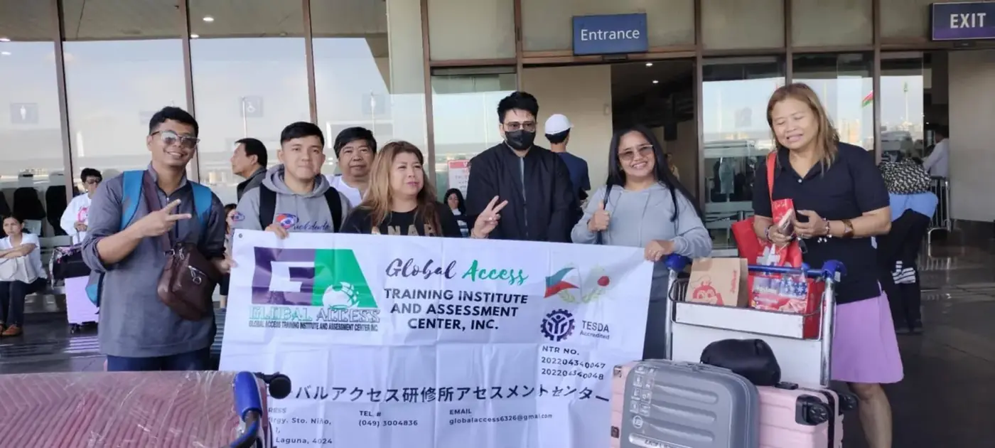 GLOBAL ACCESS banner showing the TESDA Accredited mark, held by participants at an airport