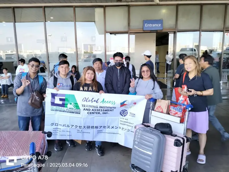 Group with luggage trolleys and the GLOBAL ACCESS banner at the airport entrance