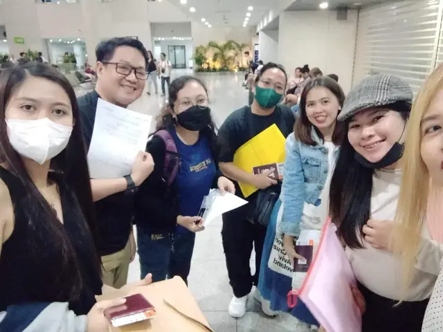 Group selfie of participants holding their travel documents