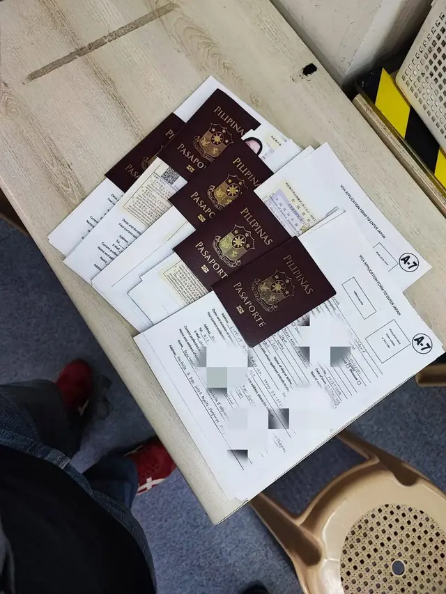 Passports and paperwork on a table with personal details pixelated