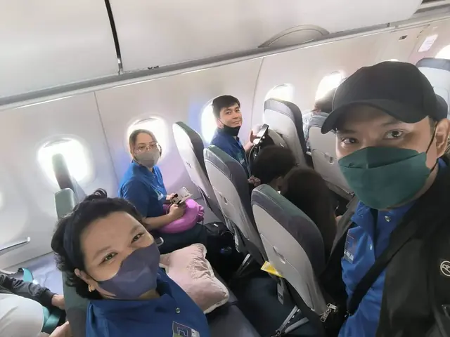 Selfie of participants in blue shirts seated inside the aircraft cabin