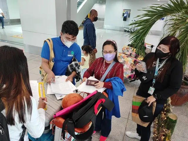 Staff helping a participant check travel documents at the airport
