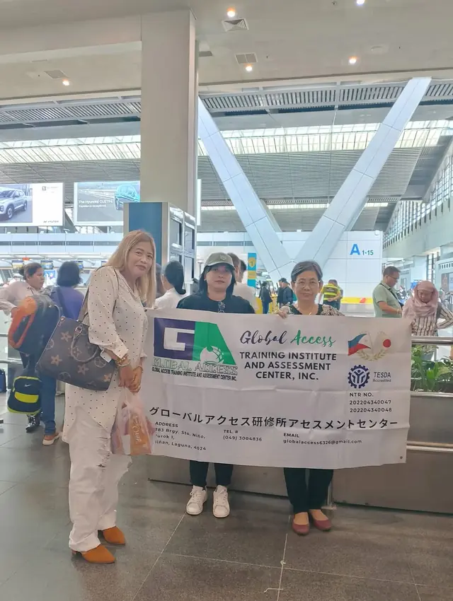 Three women with the GLOBAL ACCESS banner in the airport hall