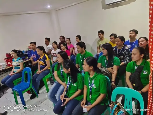 Training class participants in matching green shirts seated in rows