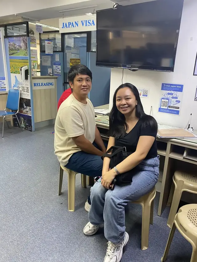 Two applicants seated inside a Japan visa application office