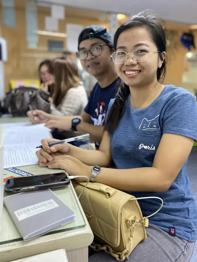 Two applicants smiling at a desk with their paperwork